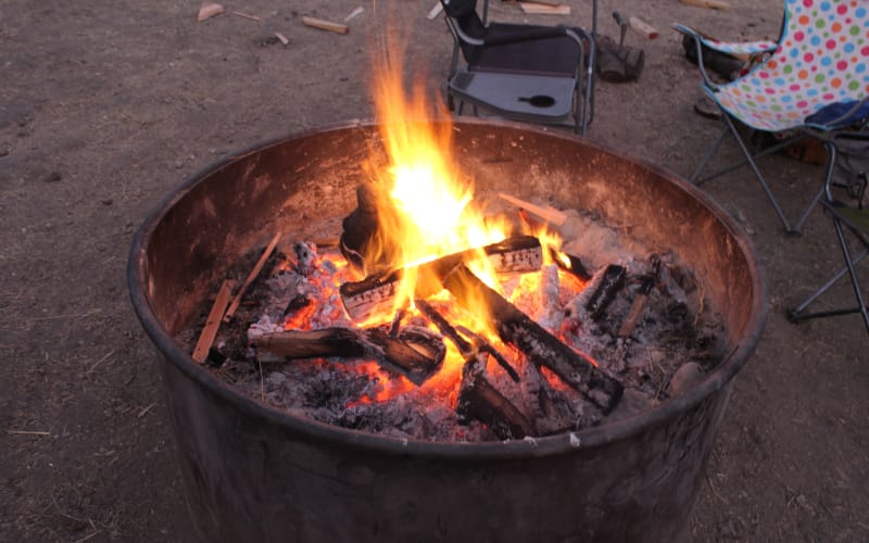 A campfire in a metal fire pit.