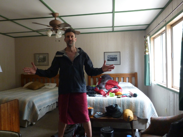 The author in raincoat and towel in his hotel room.